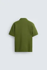 Polo de piqué color crudo, corte regular fit, cuello solapa con cierre de botonadura y mangas cortas.