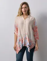 Blusa de gasa color beige con estampado floral en tonos rosa y celeste. Tiene cuello a la base, escote en V y abertura central con botones. Las mangas son 3/4 y regulables con presilla y botón.