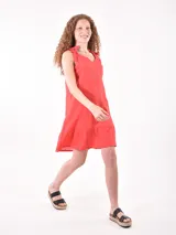 Vestido corto color crudo, de lino, con breteles finos con lazos y volado en el ruedo.