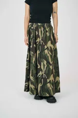 Falda maxi con estampado de camuflaje, cintura elástica y doble hebilla ajustable de herrajes metálicos. Con pliegues relajados y silueta amplia.