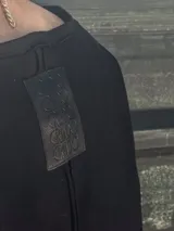 Remera negra de manga corta, con cuello redondo y calce holgado.