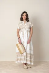 Vestido largo blanco de algodón con bordados dorados, corte recto, cintura elastizada, cuello en V y mangas cortas.