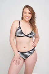 Conjunto de bikini estampado con flores en tonos naranja, rosa y celeste, con contorno y tirantes negros.