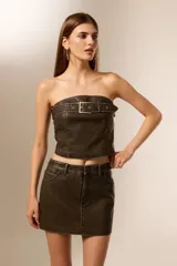Top strapless de eco-cuero color marrón oscuro, con hebilla decorativa en el frente y corte ajustado al cuerpo.