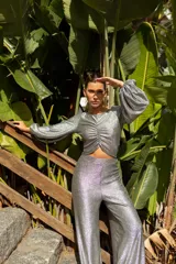 Pantalón plateado de lamé elastizado, corte palazzo y tiro alto.