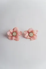 Par de aros con forma de flor de tela color rosa pálido, con centro de resina y borde de strass. Cierre a presión.