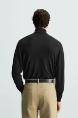 Jersey negro de punto fino con cuello alto y manga larga.