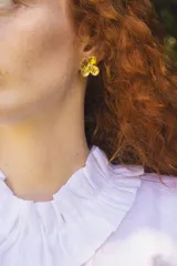 Blusa de lino color blanco, sin mangas, con cuello fruncido y volados de encaje en las sisas. Presenta pinzas frontales y un diseño de calce holgado de estilo romántico.