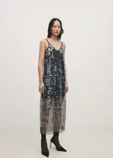 Vestido largo de fiesta con lentejuelas plateadas y negras, escote en V y tirantes finos.