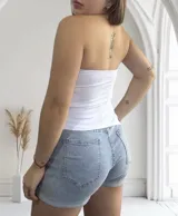 Top strapless blanco con corte asimétrico en pico.