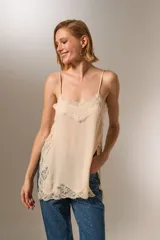 Musculosa negra de bretel fino con encaje en escote y ruedo, de corte holgado y escote profundo.