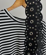 Cinturón negro de cuero sintético con apliques circulares y tachas plateadas.