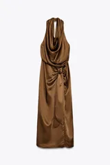 Vestido midi color marrón de satén, con cuello halter fluido y espalda descubierta. Presenta un nudo en la parte delantera, abertura frontal y cierre trasero con cremallera oculta.