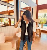 Chaleco marrón de gamulan con interior de piel sintética negra, reversible, con bolsillos laterales y corte recto.