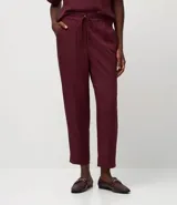 Pantalón femenino de corte fluido, color rojo vibrante, con cintura elástica ajustable mediante lazo y bolsillos laterales.