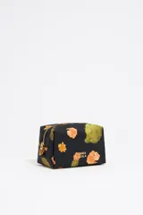 Neceser pequeño de nylon color negro con estampado de flores y cactus. Tiene cierre con cremallera dorada, logo metálico de la marca y bolsillo interior.