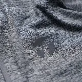 Camiseta deportiva gris jaspeado de calce entallado, con cuello alto y cierre parcial.