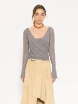 Sweater gris compuesto por un top inferior de breteles y un sweater superior de manga larga con escote en V cruzado. Ambas piezas están confeccionadas en tejido liviano de lana mezclada.