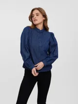 Camisa de denim color azul oscuro, de manga larga con hombros abullonados y puños ajustados con botón. Presenta cuello clásico y cierre frontal de botones.
