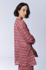 Kimono con estampado étnico en tonos rosa, rojo y blanco.