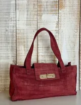 Cartera tote bag color borgoña, con textura tipo piel de cocodrilo, cierre con solapa y herraje dorado.