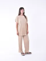 Blusa negra de corte holgado y mangas cortas, con textura plisada.