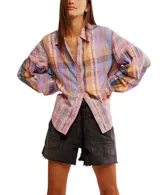 Camisa a cuadros de corte relajado y extragrande, confeccionada en un tejido liviano de algodón. Lleva cuello clásico, cierre frontal con botones y mangas largas con hombros caídos. Los detalles de volantes en los ribetes aportan textura y un toque distintivo, mientras que los puños se ajustan con botón.