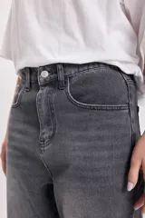 Pantalón jean gris oscuro de corte recto con bajo doblado.