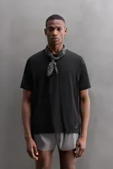 Camiseta deportiva verde militar confeccionada en tejido estructurado, ligero y elástico. Tiene cuello redondo, manga corta y bajo con aberturas laterales. Incluye logo estampado en el bajo.