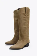 Bota alta color marrón de serraje, con puntera terminada en punta y taco cuadrado.