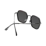Lentes de sol con marco geométrico negro y lentes grises.
