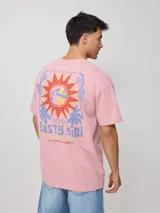 Remera negra de algodón con estampado en la espalda que incluye un sol estilizado, texto con la marca "Rusty" y la frase "Golden Sun - Endless Waves".