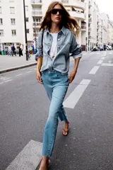 Pantalón de jean color crudo, de tiro alto, corte recto y largo tobillero. Tiene cinco bolsillos, cierre frontal con cremallera y botón metálico.