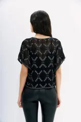 Blusa negra de georgette con bordados de hilo y canutillos, mangas cortas y calce relajado. Incluye viso interior con puntilla y breteles regulables.