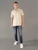 Chomba de algodón color beige, de mangas cortas, con tapeta de dos botones y logo tonal de Calvin Klein. Prenda suave y ligera, de corte clásico.