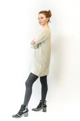 Vestido corto tejido color beige, con mangas largas y corte holgado, inspirado en el diseño de un buzo clásico.