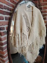 Ruana color crema tejida en lana merino con bordados a mano sobre lino.