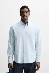 Camisa azul marino de algodón con textura jacquard, corte relaxed fit, cuello solapa, manga larga con puños abotonados y cierre frontal con botones.