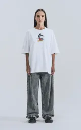 Remera blanca de algodón con cuello redondo y calce oversize. Estampado en la espalda de Mickey Mouse andando en skate con llamas y texto "Hot Diggity Skate Dogs".
