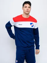 Buzo de felpa con cortes y cambios de color rojo, blanco y azul. Incluye el escudo del Club Nacional de Football y las siglas C.N.deF.