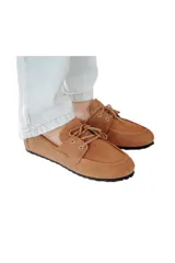 Mocasín color caramelo de cuero gamuzado con lazo frontal y detalle de pasacintas laterales. Suela flexible antideslizante.