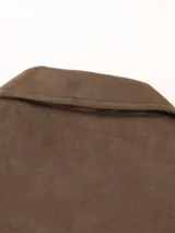 Blazer marrón de gamuza con cuello de solapa, cierre con botones y bolsillos frontales.