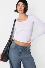 Crop top blanco al cuerpo sin mangas de morley de algodón, con detalle de collareta en mangas y cuello, terminación de ruedo recto.