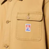 Campera color beige con cuello clásico, cierre frontal con botones a presión, bolsillo de parche en el pecho izquierdo con etiqueta de la marca y dos bolsillos de parche inferiores. Corte recto y mangas largas.