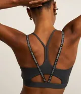 Top deportivo gris oscuro con breteles finos con lettering y estampa frontal con la palabra "Sporty".