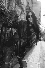 Blazer entallada de cuero negro con cuello solapa, manga larga con abertura, bolsillos con solapa y cierre frontal con botones.