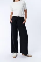 Pantalón negro de vestir, de corte palazzo y tiro alto.