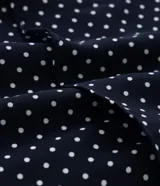 Pollera midi de crepé azul marino con lunares blancos, cintura elástica y volados en capas.