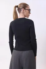 Sweater negro de punto con cuello redondo y mangas largas.