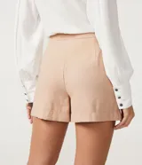 Short color beige de viscosa con cintura alta, solapa con botones y bolsillos laterales.